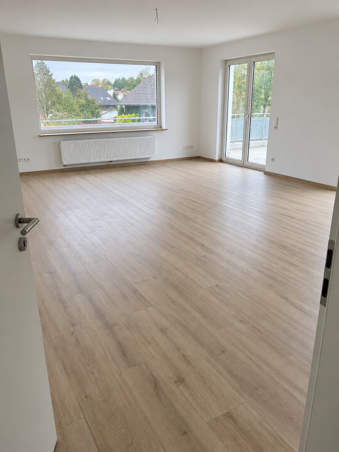Derselbe Wohnraum nach der Bauendreinigung mit sauberen Böden, Fenstern und Randbereichen