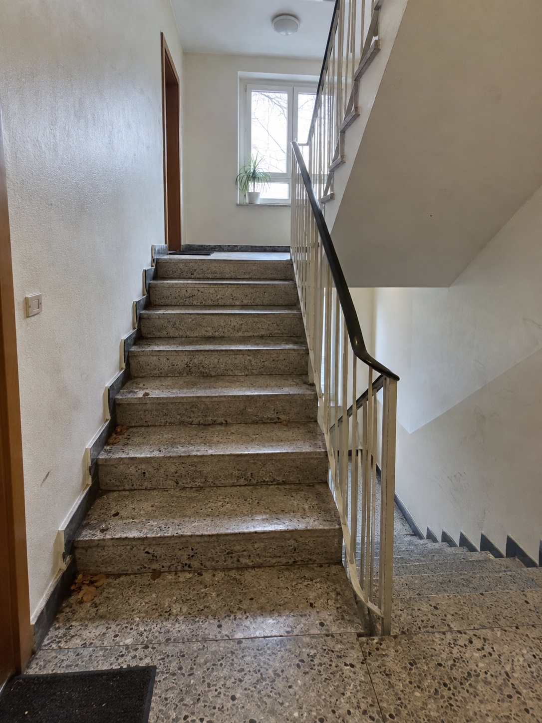 Treppenhaus vor der Reinigung mit Schmutzspuren und Ablagerungen auf Stufen und Podest
